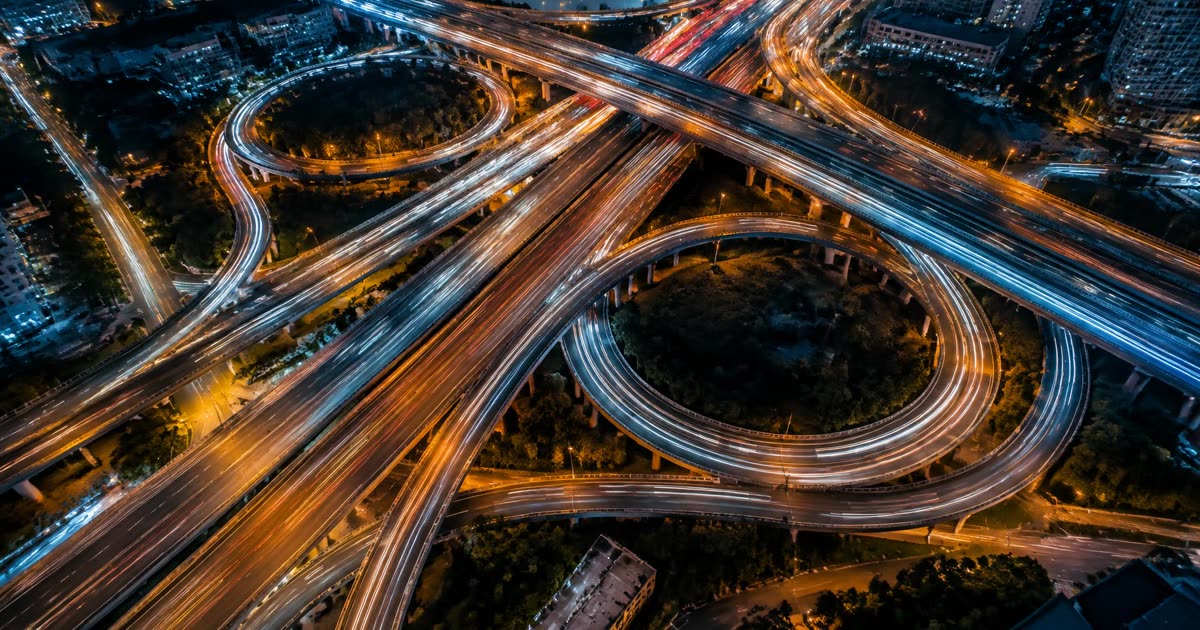 Aerial view of a highway interchange with orange and blue light trails