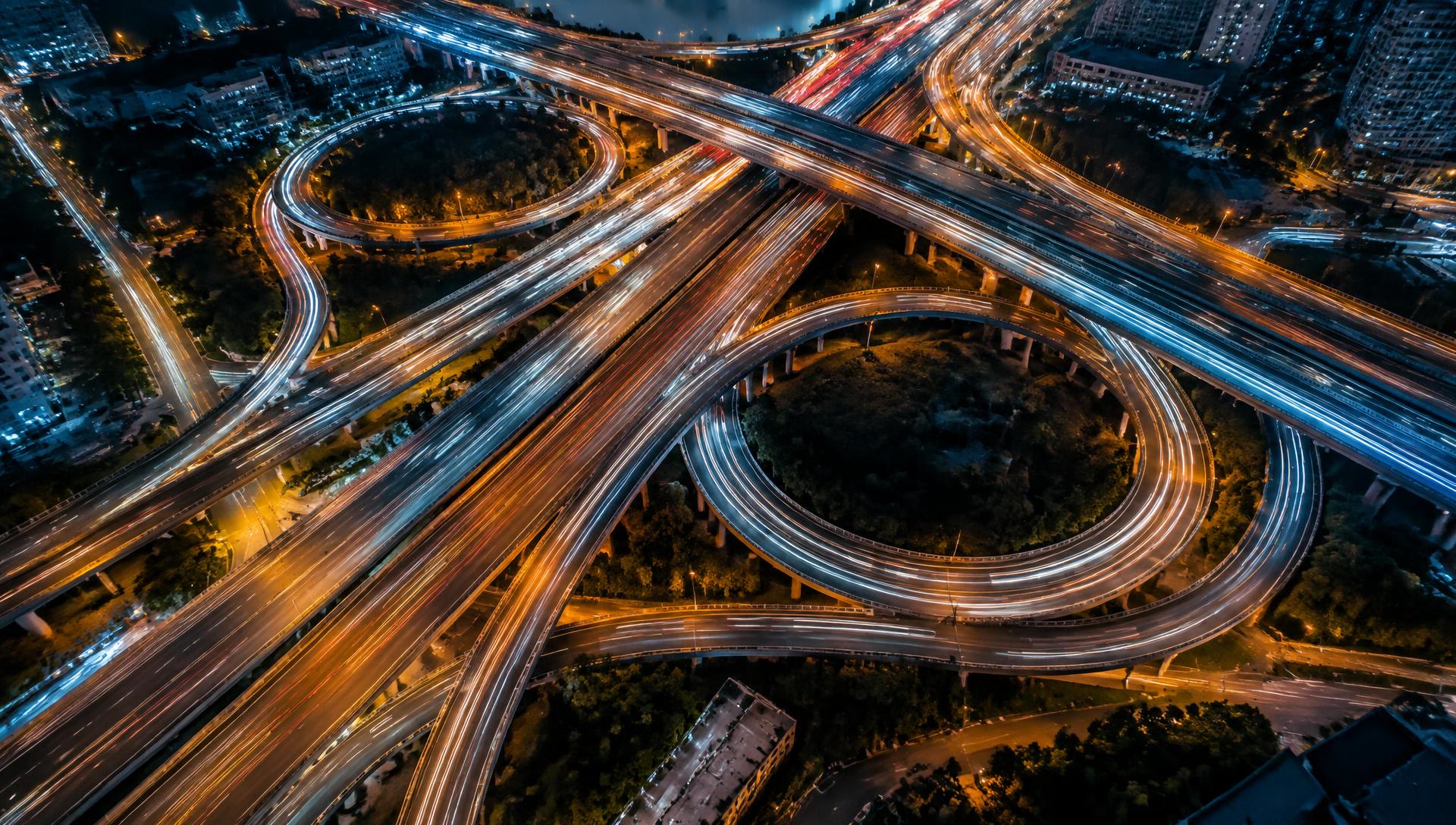 Aerial view of a highway interchange with orange and blue light trails